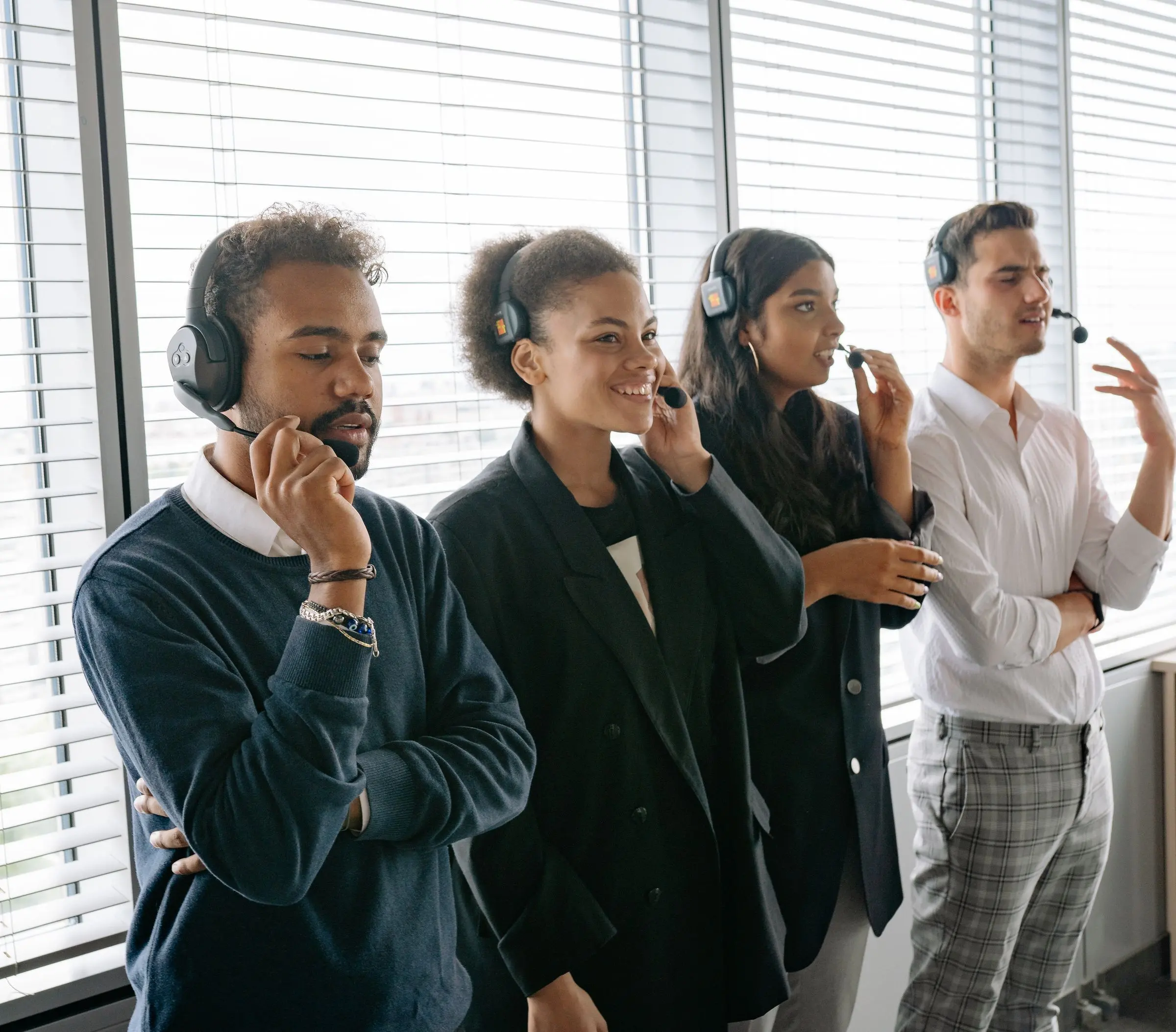Customer service colleagues wearing headsets in an office